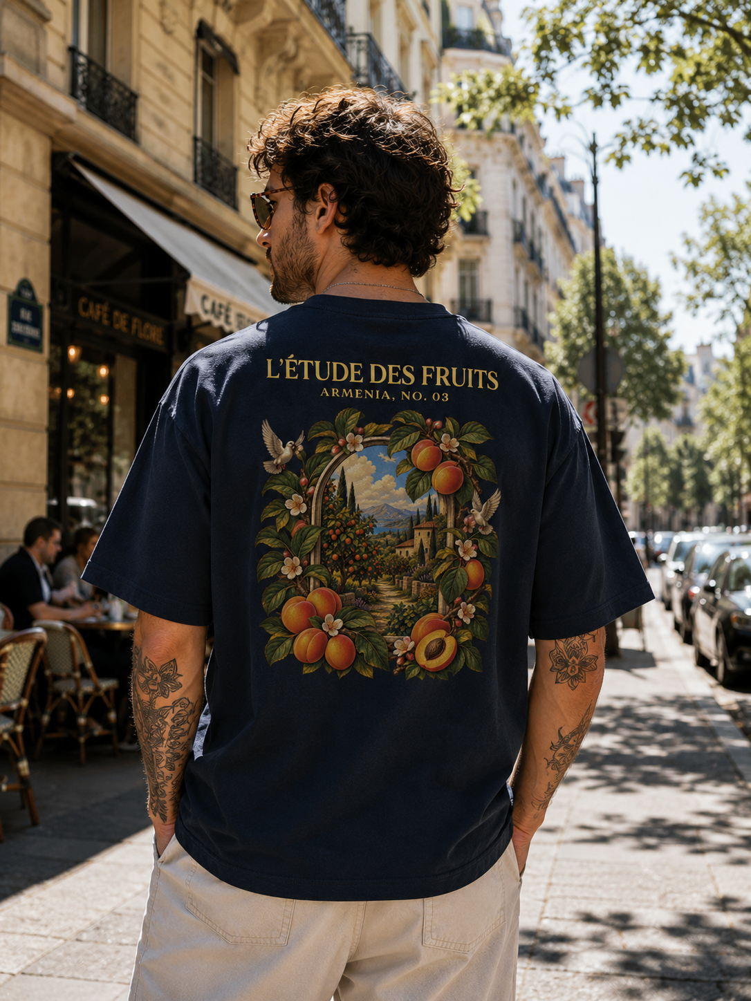 Man wearing L'Étude des Fruits Armenia No. 03 golden apricot back graphic heavyweight tee in navy